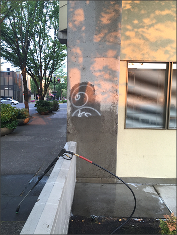 Removing graffiti from a Eugene building with pressure washing